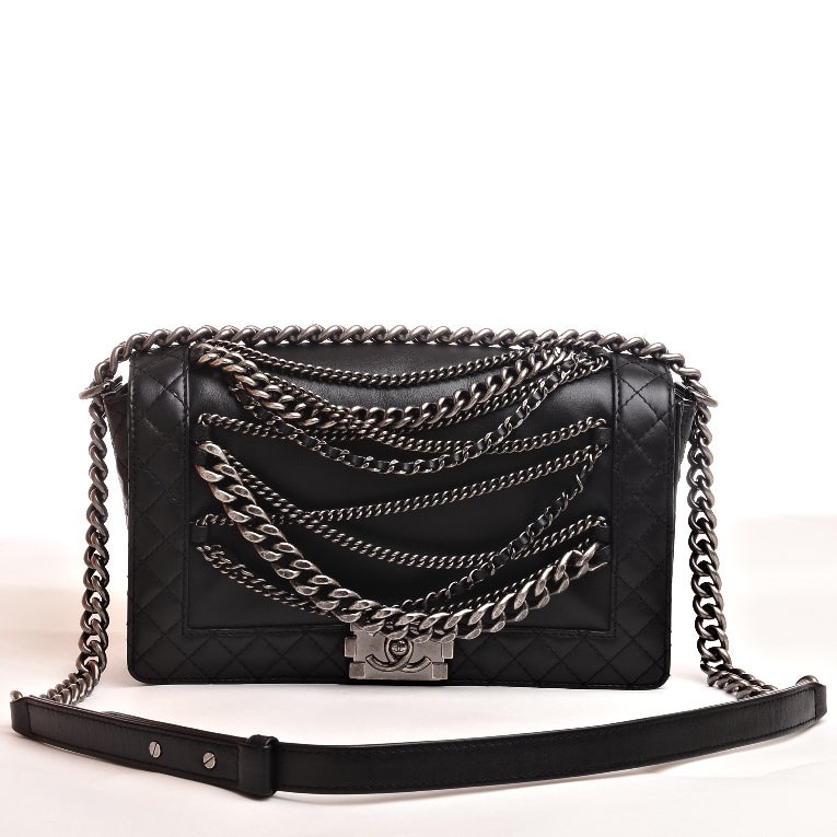 Chanel black quilted calfskin leather Enchained Boy flap bag featuring front draped metal chain link detail with antiqued silvertone hardware, front CC push lock closure and antiqued silvertone chain link and black leather padded shoulder strap.