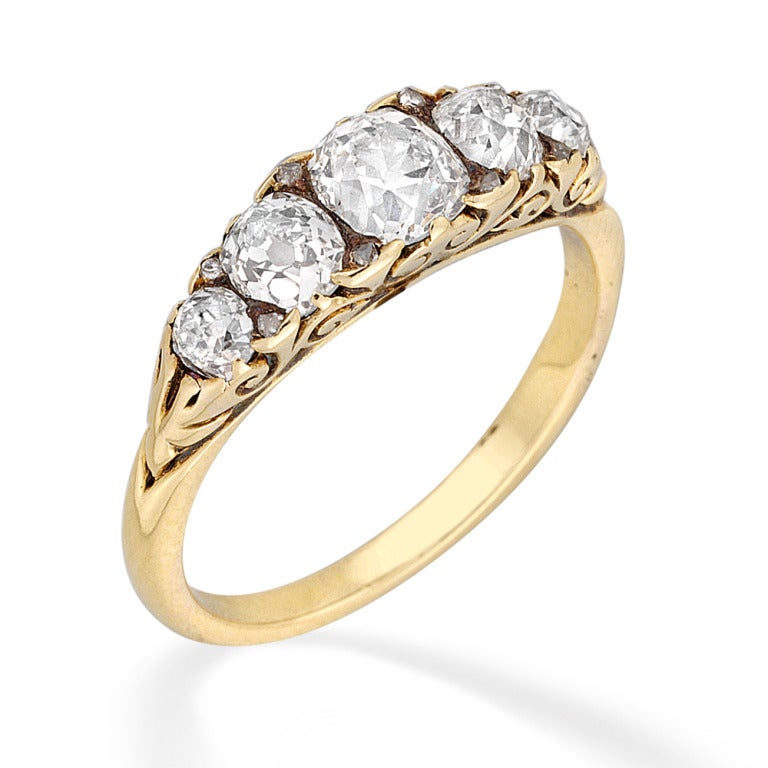 A Victorian five stone carved half hoop diamond ring, the five graduating old-cut diamonds weighing approximately 1.3 carats in total all set to a yellow gold srolled carved gallery and tapered D-section shank, gross weight 3.6 grams.