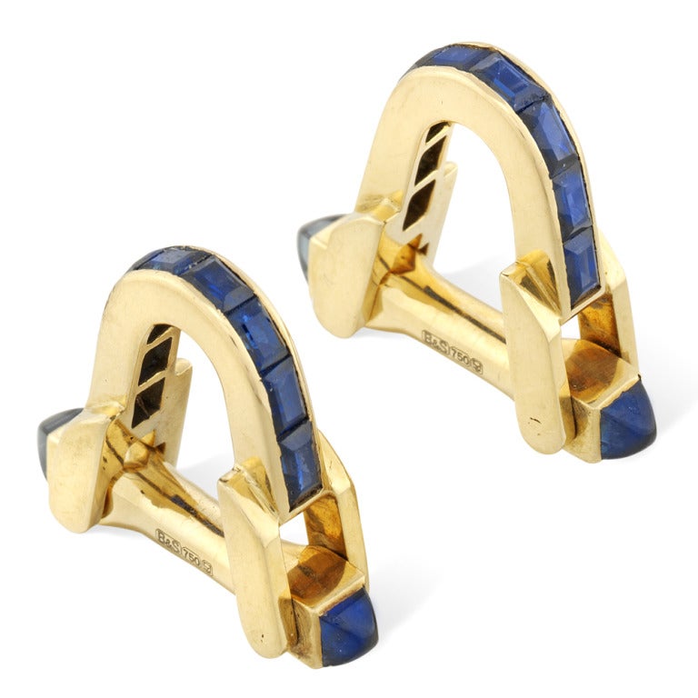 A pair of  1930s Boucheron sapphire and yellow gold stirrup cufflinks, each cufflink set with eight rectangular step-cut sapphires channel-set in 18 carat yellow gold, to a hinged bar fittingwith square, egg-shaped cabochon-cut sapphires to either