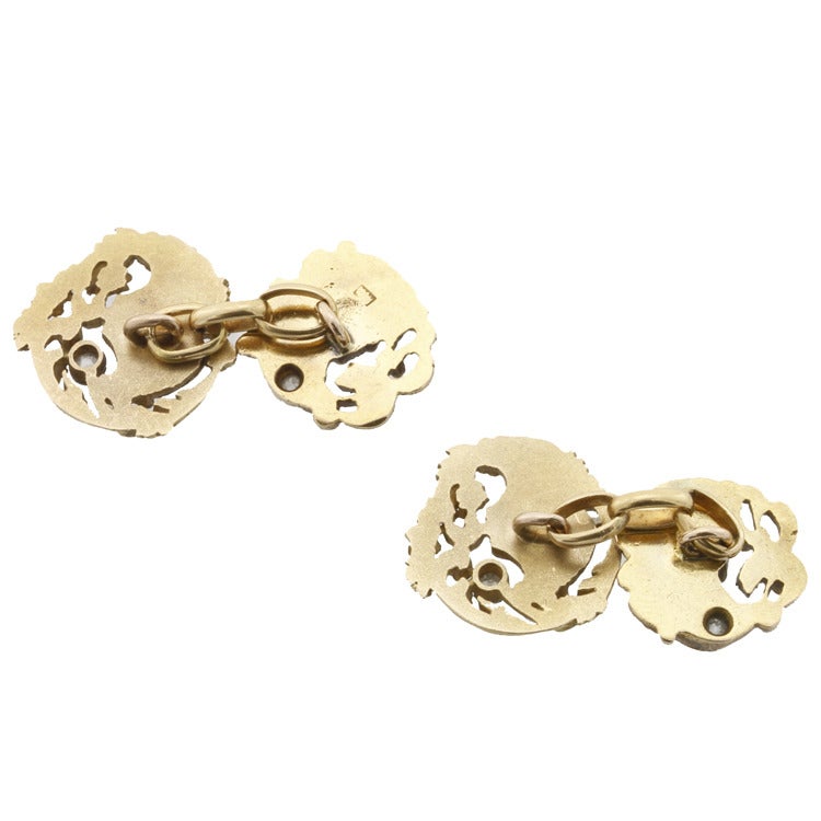 A fine pair of Art Nouveau yellow gold cufflinks, each cufflink comprised of two circular open-work plaques, each with a female profile in relief with flowing ringlets amongst floral motifs, highlighted with rose-cut diamonds the two plaques