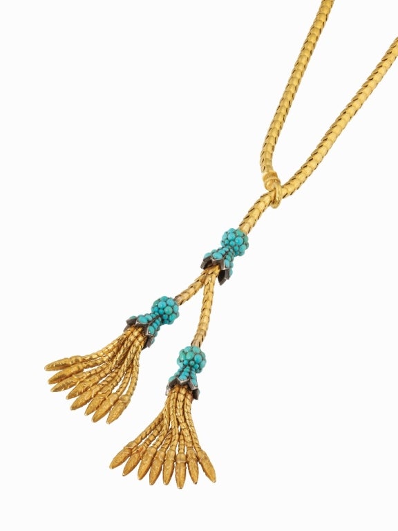 A Victorian gold and turquoise lariat necklace, the gold snake chain comprising of three cabochon-cut turquoise-set caps, ending with foxtail fringes, circa 1870
Gross weight 47.99