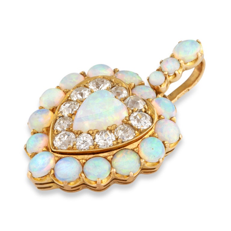 A Russian opal and diamond heart pendant, the heart-shaped opal set to the centre of an old brilliant-cut diamond cluster surround, the eleven diamonds estimated to weigh a total of 2 carats, all to a heart-shaped border set with fourteen