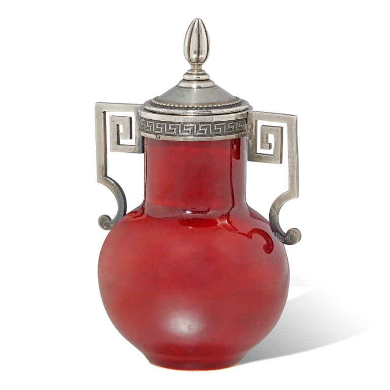 Un pot à gomme sang-de-beouf Fabergé monté en argent en forme d'urne, avec deux poignées en argent et un bord décoré d'un motif de clé grecque, un couvercle convexe en argent avec un entourage perlé surmonté d'un fleuron en forme d'urne, l'intérieur