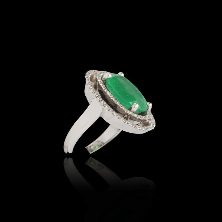 Gold, emerald and diamond ring.

White gold 18K (750 milliÃ?¨mes) ring. Ornated with one oval emerald of approx. 4 carats, within surrounding of two rows of modern-cut diamonds in prong settings.

Total weight of diamonds: approx. 0,68