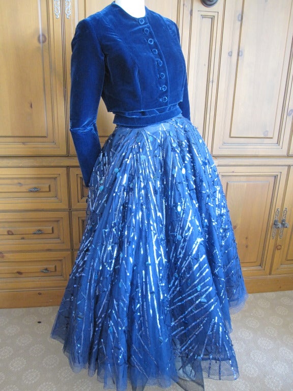 Sophie of Saks original 1950.
Gorgeous blue dress with a velvet bodice and a mile wide tulle skirt shot with Paillets and sequins.
The skirt is 3layers of tulle and another full skirt horsehair.
Metal zipper