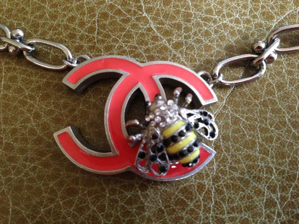 Chanel Bee Logo Necklace.
Silvertone necklace with enameled bee
pendant measures 1 1/2
