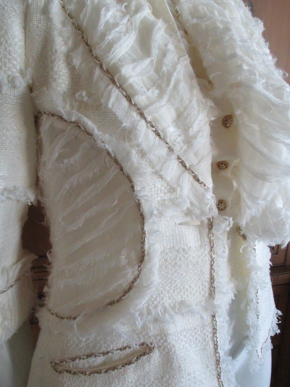 Chanel ivory elaborate embellished vest and jacket set
From Spring 2008
sz 36
The workmanship is incredible, please look at the photos to see the handiwork of the petite mains of Chanel.
Vest has intricate chain details on the back, and chains
