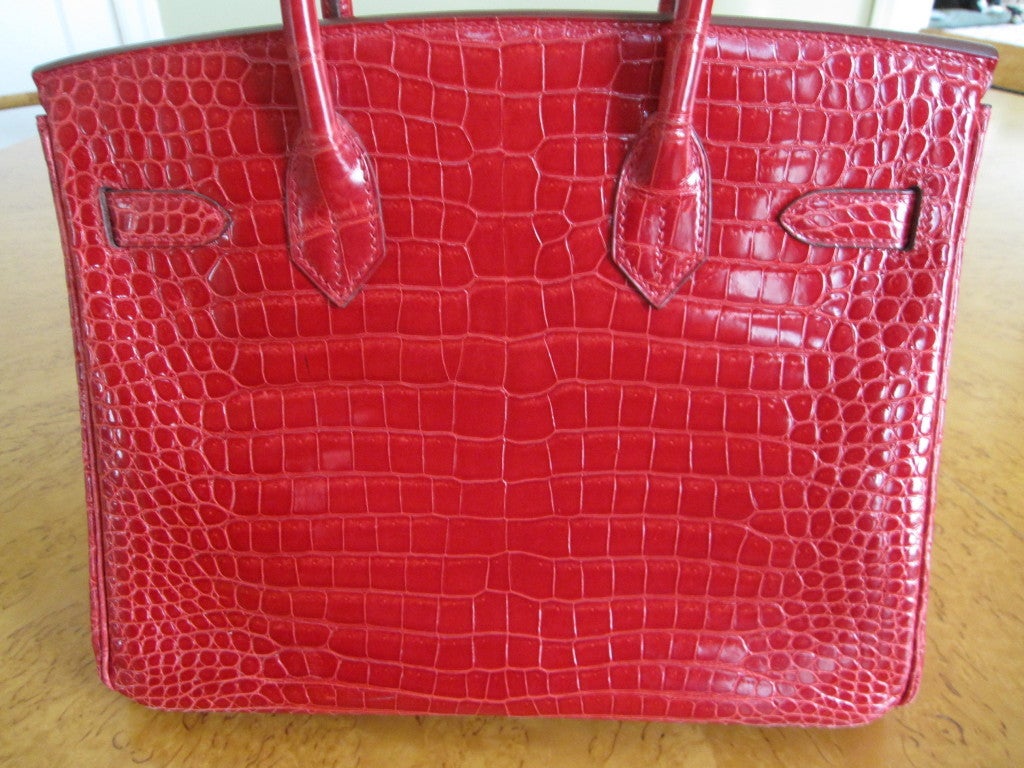 This smashing hard-to-find 30cm crocodile Hermes Birkin is truly like new, carried only a handful of times. This rich cherry red color is called 