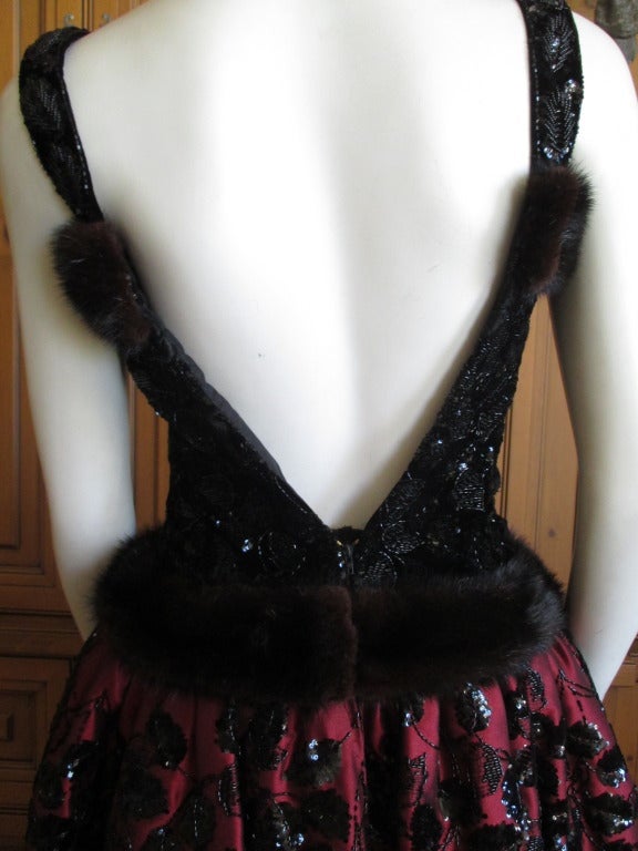Nina Ricci Haute Couture Mink Trim Beaded Backless Dress.
From the Gérard Pipart era at Nina Ricci.
This is so charming. From the front it has all the  Opulance Ricci was famous for;heavy beading, fur trim and the bold rose coursage. So it is a