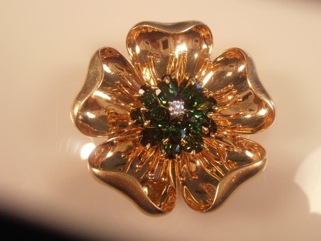 A gorgeous Signed Tiffany, Vintage 18 karat  yellow gold, beautifully articulated, three dimensional  “Dogwood” brooch set with 14 very fine, oval shape,
faceted beautiful green tourmalines totaling over 9-9 ½ carats and a single .20 carat, fine