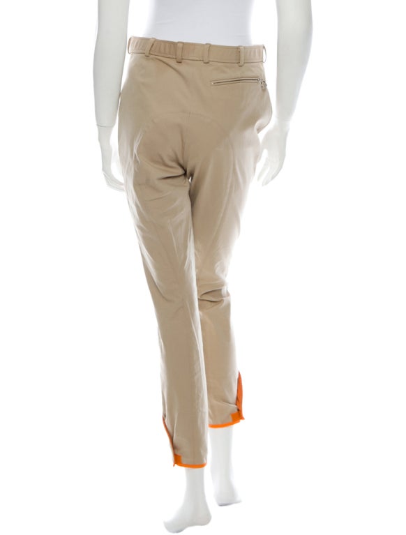 Khaki riding pants with silver-tone zippers, suede at thighs, orange trim and velcro at leg openings and front button snap closure

Waist 30”, Hip 36”, Rise 12.5”, Inseam 28”, Leg Opening 10”

64% Cotton, 29% Polyamide, 7% Elastane