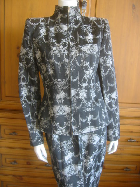 Pre 2002 Vampire Ensemble.<br />
High neck jacket with a bustle mermaid skirt with a small train.<br />
Black and White Floral inartsia brocade.<br />
Jacket zips up front<br />
Sz 44<br />
This gorgeous suit is from Mcqueens early phase of