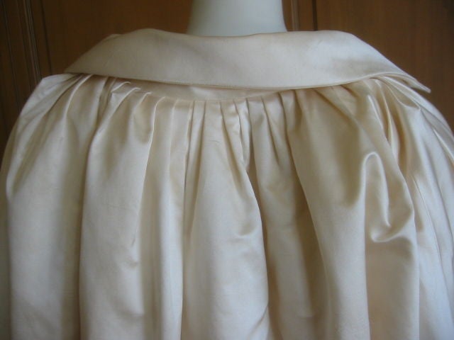 Oscar de la Renta Silk satin Coat.<br />
The details on the back and upper sleeves are really beautiful.<br />
Inside is lightly quilted.<br />
This is an Ivory white.<br />
Sz 4 <br />
Because of all the pleatig on the back,the cut is very