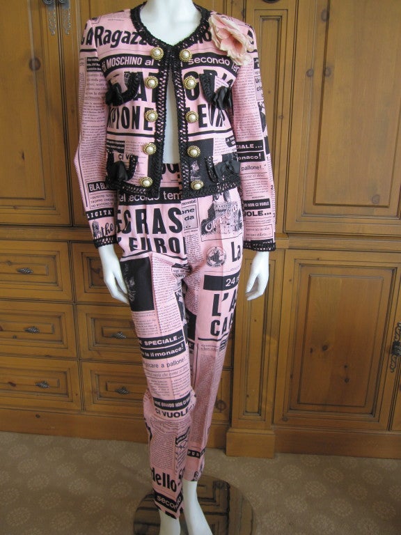 Moschino Couture 1983 Newspaper Print suit smiley face buttons.<br />
In a gentle riff on Coco Chanel, Franco Moschino created this witty send up of a Chanel suit.<br />
With comedy clippings of newspapers, fancifull bows and gold trimmed pearl