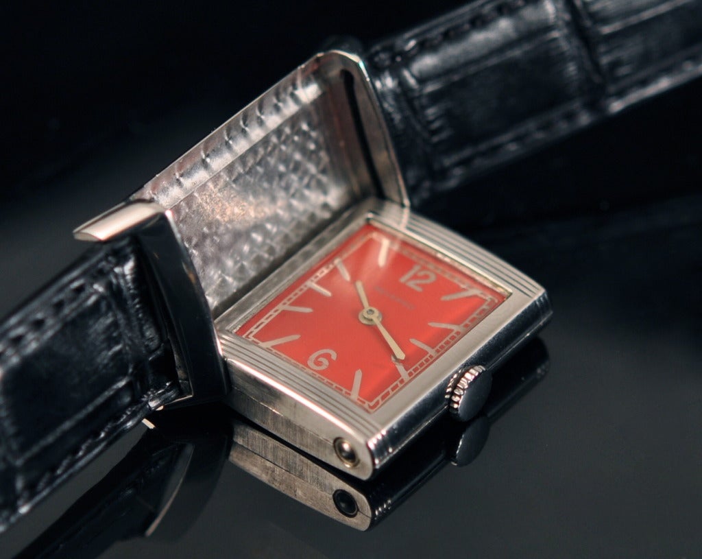 Jaeger-LeCoultre rectangular Reverso wristwatch with manual-wind movement and red dial.