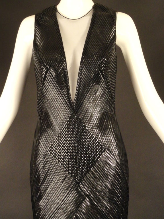 Amazing evening gown from the Spring, 2013 Runway Collection. The sheath gown is made to fit like a glove. It's made of contrasting panels that are interwoven with narrow strips of black patent leather stitched to a fine netting. If you notice in