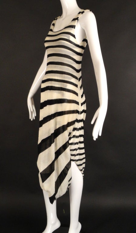Spring, 2011 Runway Collection for Comme Des Garcons. The black and white stripe dress is made in a lightweight wool gauze. The dress is doubled, with the front and back panels connected along the hemline. The hemline twists in some manner which
