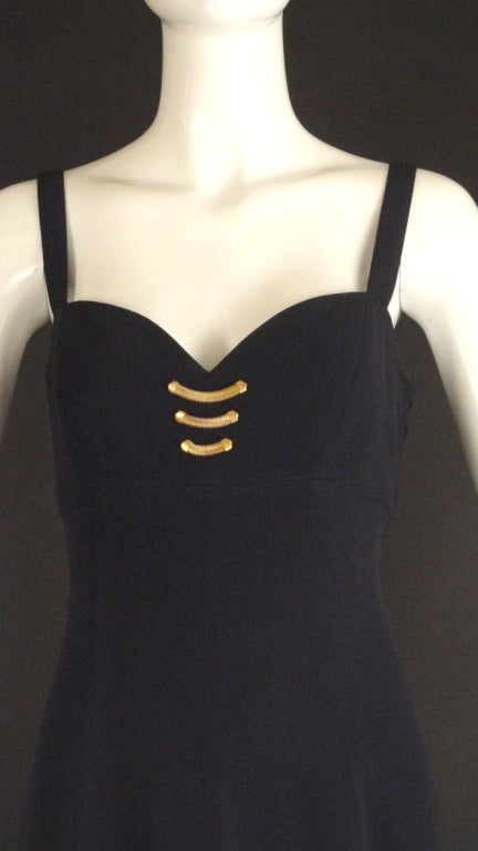 1990s Maxi dress in a black wool crepe. Slip style with wide shoulder straps. Empire waistline and a dart fitted bodice. Full, gored skirt with a center front slit. Black silk chiffon underskirt has no slit. Gold chain decoration between the bosoms.