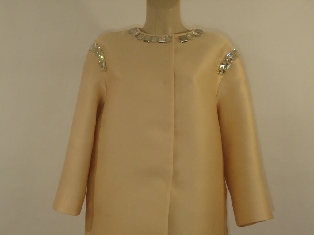 Wonderful Prada light overcoat.

Colour rose antique with a tendency to peach.
Big rectangular crystals at the collar and on the shoulders

67% polyester, 33% silk

Lining : 100 % silk

Decoration : 65% glass and polyester.

Made in