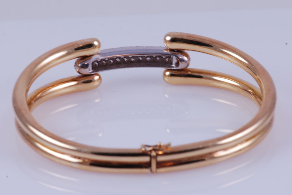 18kt gold heavy modern style bangle bracelet with approx. 2 carats of very white diamonds. The diamonds are set in white 18K gold.

The bracelet is signed Natan, as seen in figure 3. This is a larger bangle, measuring 2.5
