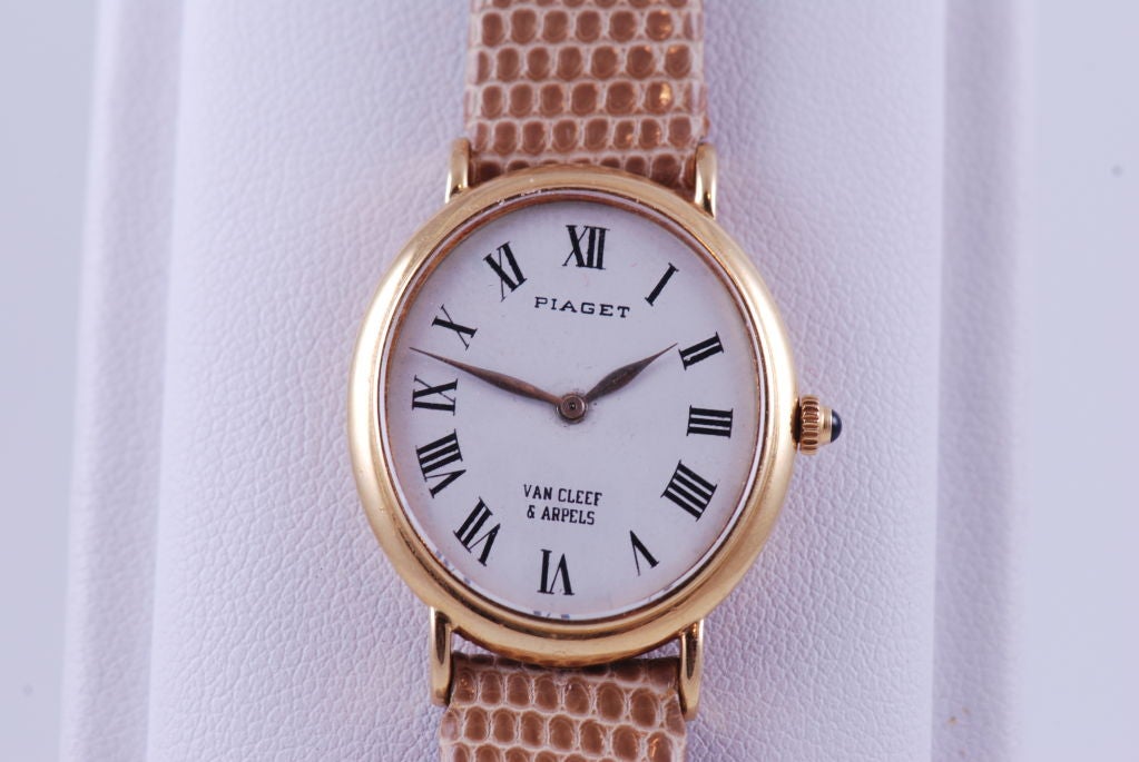 Piaget ladies  wrist watch in 18k yellow gold which was retailed by Van Cleef & Arpels. Cabochon sapphire on stem crown. Beige lizard strap. Oval shaped  measuring 1 1/16