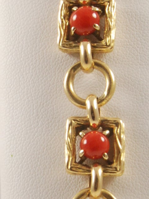Tiffany 18k gold link bracelet set with 7 coral cabochons. Bracelet is circa late 1960's - 70's. The links are solid gold and the bracelet weighs approx. 35 dwt.

The clasp is hidden under one of the links so to give a very neat