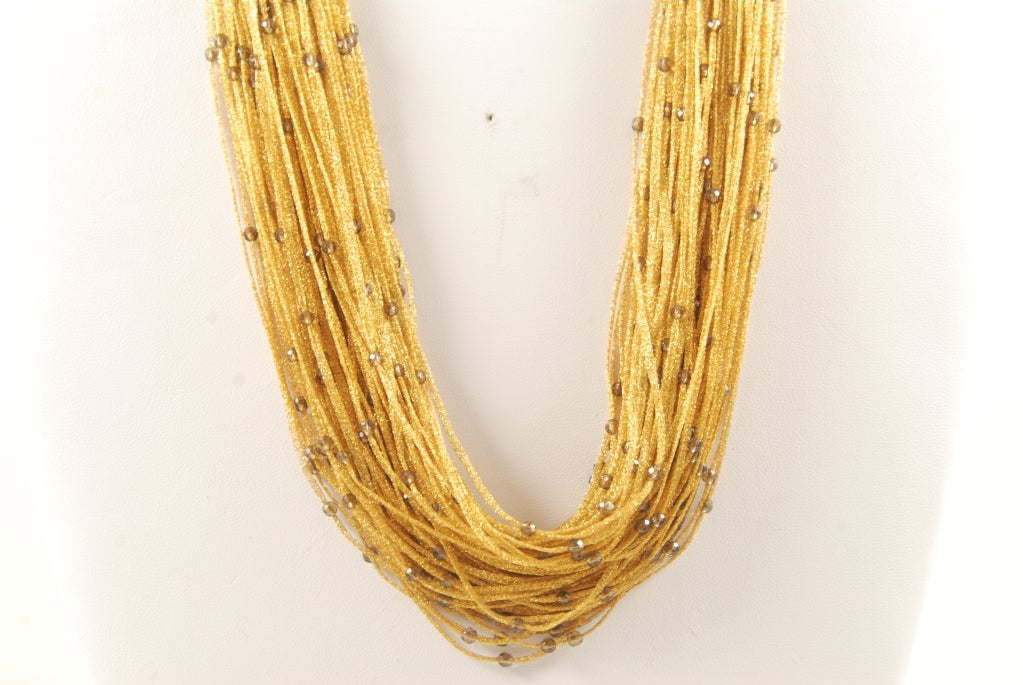 18k gold multi strand necklace with interspersed small smokey topaz faceted beads. The clasp is 18k gold and has diamonds. The necklace has an ethereal feel because each chain is so pliable. It lays beautifully on the neck. The shortest length is 17