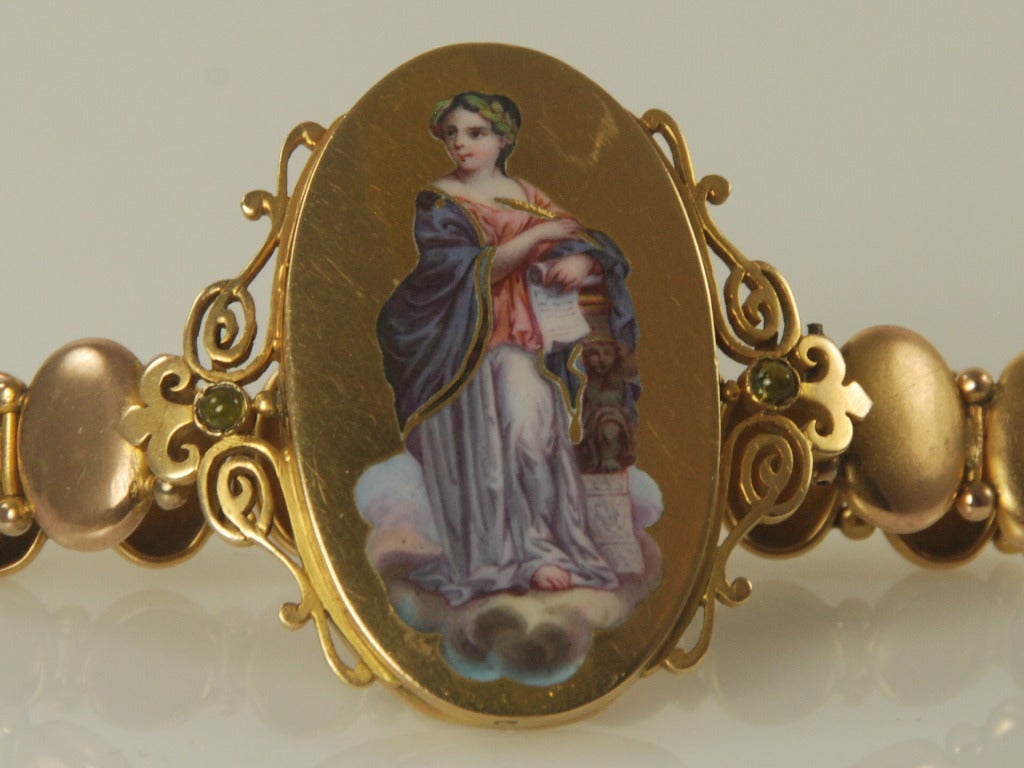 Late Victorian bracelet with a large center plaque depicting a portrait of a woman in a classical pose done in enamel. On either side of the plaque is a cabochon peridot. The center plaque and the surrounding gold work id done in 14K gold. The