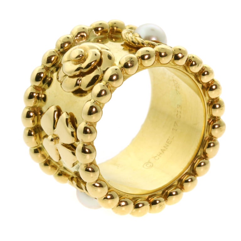 This bold Chanel ring is from the Camelia collection, it features 2 pearls followed by 2 Camelia Flowers and 2 Four Leaf Clovers. The ring is crafted out of 18k Yellow Gold weighing 18.9, and is a size US 5.
