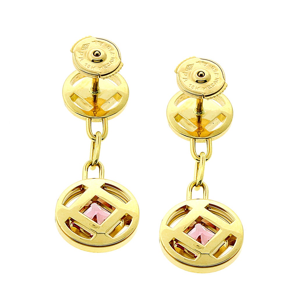 Brand new Cartier Pasha Diamond earrings features 2 step cut Pink Sapphire stones. These earrings are crafted out of 18k Yellow Gold, and have a weight of 8.8 grams. The total length of the earrings is 32mm and have a width of 10-12mm.