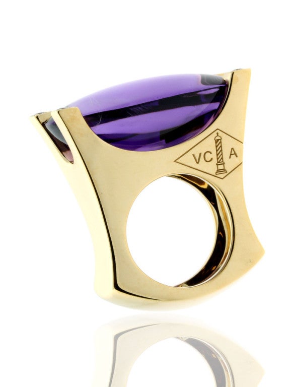 A fabulous Van Cleef and Arpels cocktail ring featuring a vivid amethyst encased by 4 of the finest Van Cleef and Arpels round brilliant cut diamonds in 18k yellow gold.

Size: 6 1/4, EU 53
Dimensions: 1.26 Inches wide

Inventory ID: 0000216