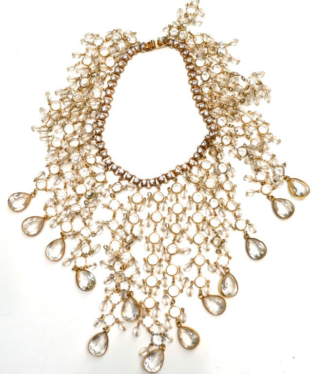 This William De Lillo necklace is as collectible as it is a wearable statement piece. The choker style piece hangs from the center of the neck into the breast area and sides of the chest area.  The book chain with rhinestones and the tear drop glass