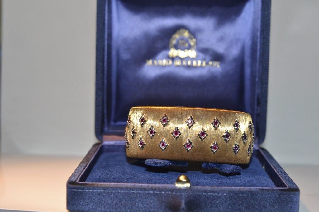 Designed as a textured 18k yellow gold cuff , decorated with circular cut rubies each within a sculpted white gold navette shaped surround.
Signed M. Buccellati
coming with certificate and original box