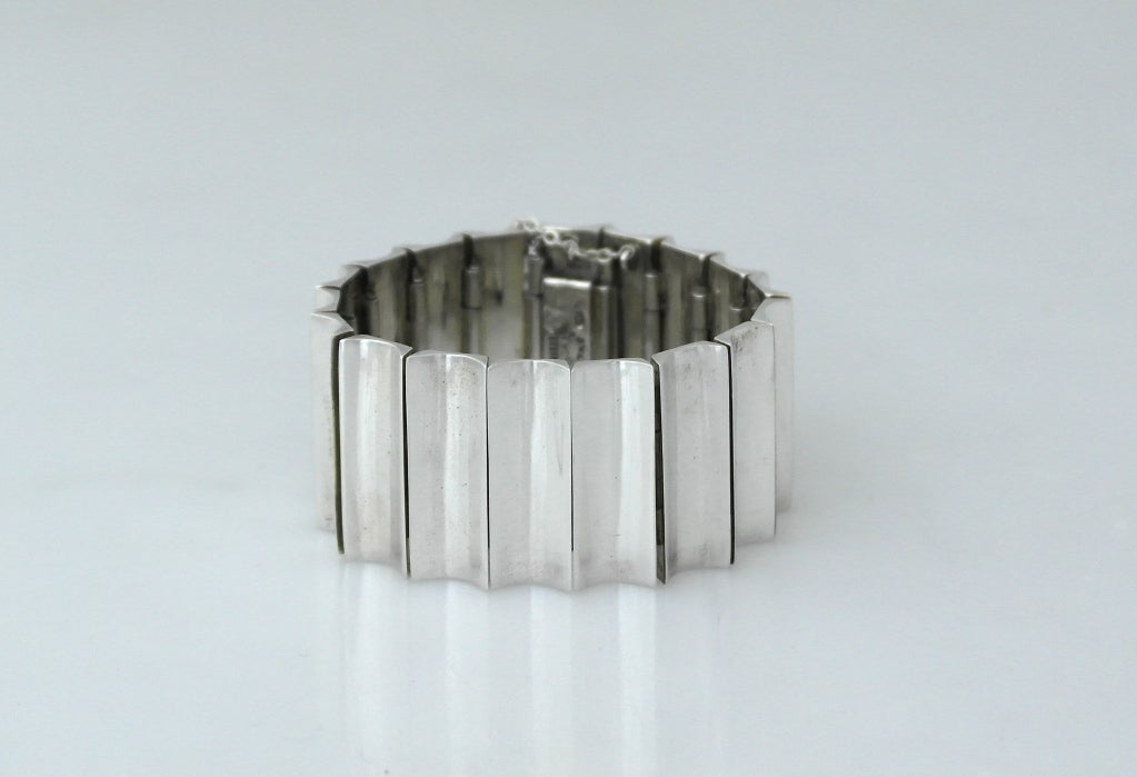 Being offered is a circa 1955 sterling silver (actually .970 purity) bracelet by Antonio Pineda of Taxco, Mexico; of modernist design, i.e. sleek yet chunky, with concave shaped links and a mirror-like finish.  Measures a closed, wearable length of