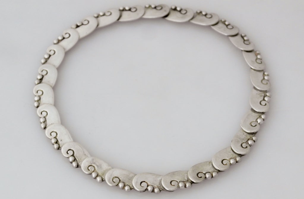 Being offered is a circa 1949 sterling silver choker necklace by Hector Aguilar of Taxco, Mexico; link-style with scroll & two beads on each link. Dimensions: 14 3/4