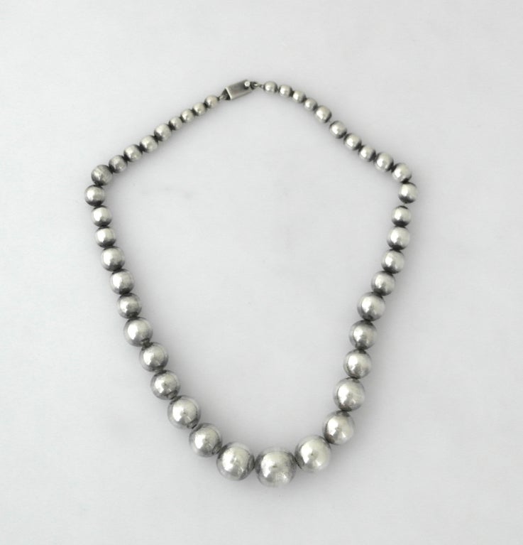 Being offered is a circa 1960 sterling silver necklace by Jose Marmolejo of Taxco, Mexico. Heavy piece comprised of hand made sterling silver balls that graduate in size; tongue & box closure. Marmolejo often designed pieces for the well known
