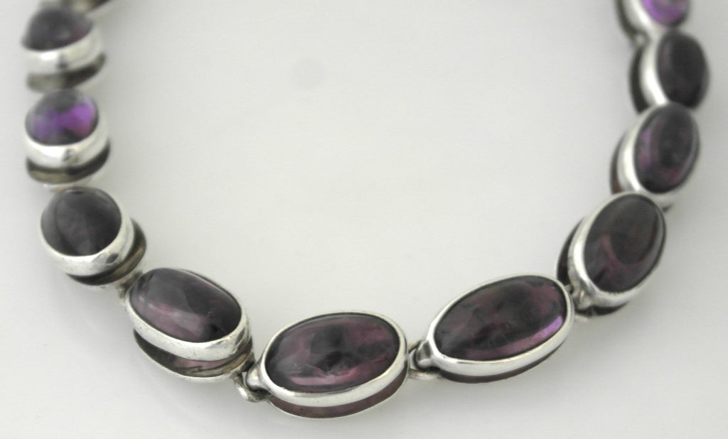 Being offered is a circa 1955 sterling silver parure by Antonio Pineda of Taxco, Mexico; consisting of a necklace, bracelet & lever-back earrings adorned with large amethysts. Dimensions: Necklace - 16 1/2