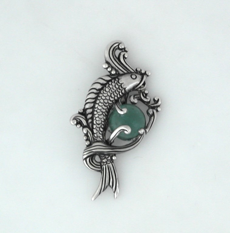 Being offered is a fine circa 1955 sterling silver and aqua glass brooch by Los Castillo, of Mexico, a stylized fish swimming thru the water.  The detailed engraving is amazing.  Dimensions: 3 1/2 inches by 1 3/4 inches.  Marked as illustrated. No