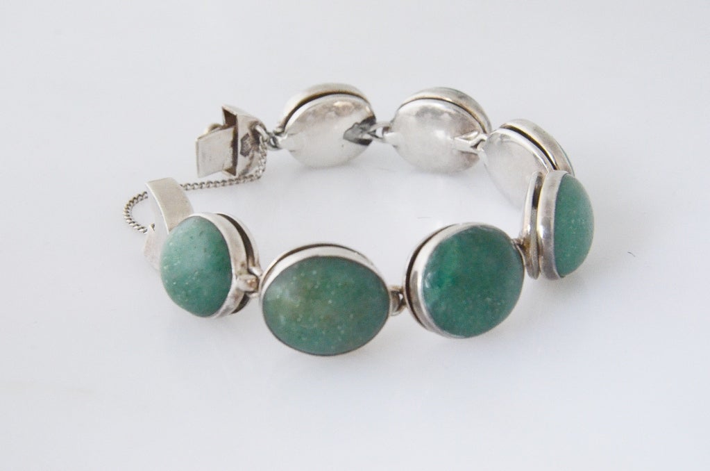 Being offered is a circa 1960 .970 silver and jade cabochon bracelet by Antonio Pineda of Taxco, Mexico, with seven linked sections, each set with a cabachon jade stone. Construction is superb, bracelet secured by box clasp and chain.   Weighs 122