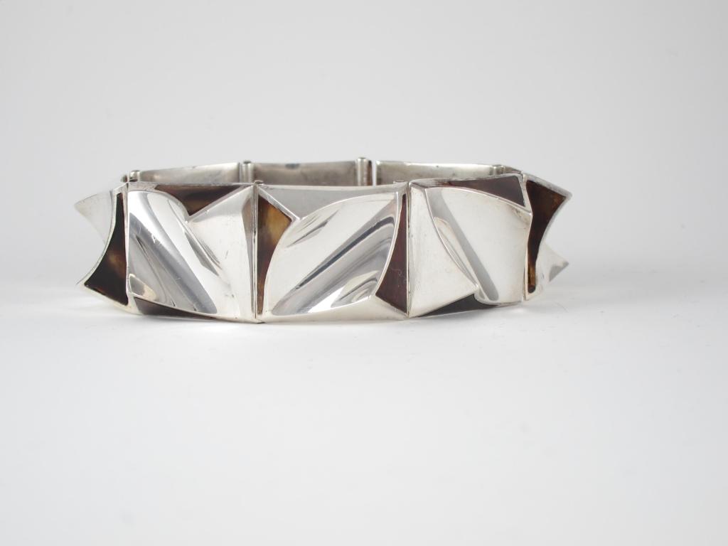 Being offered is an exceedingly rare circa 1950s .970 silver bracelet by Antonio Pineda of Taxco, Mexico; comprising a modernist concave design with inlaid shell at opposite ends of each link.   The design is a rapturous flow of silver and shell, so