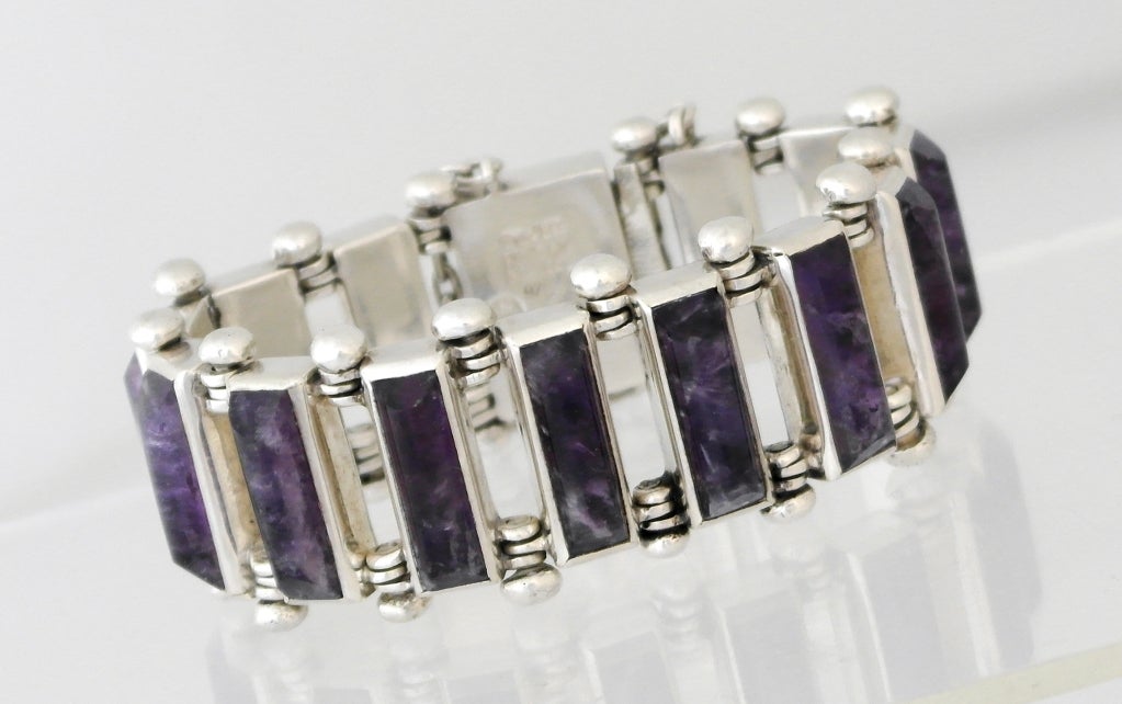 Being offered is a circa 1958 .970 silver and amethyst bracelet by Antonio Pineda of Taxco, Mexico, of modernist style, with amethysts bezel set, the links connected in a motif reminiscent of the gears of a bicycle.  Length 7 1/2 inches.  Marked. 