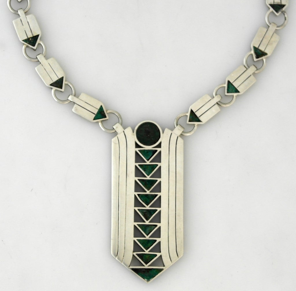 Being offered is a circa 1950 sterling silver and hardstone necklace by William Spratling of Taxco, Mexico, the iconic arrow-form pendant and chain set with azur-malachite as the arrow points, the pendant 3 1/2 inches long, the rectangular linked