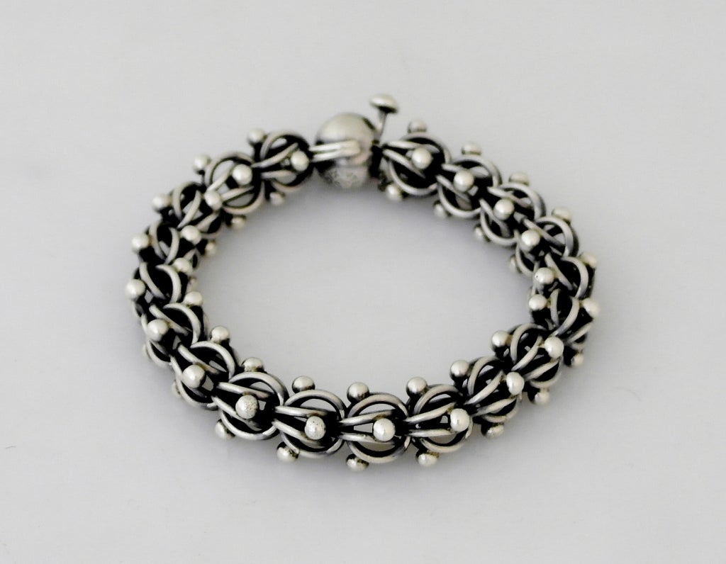 Being offered is a circa 1959 .970 silver bracelet by Antonio Pineda of Taxco, Mexico. of modernist design, the construction reminiscent of a DNA construction, the balls and swirled links constructing individual ball links.  Length 7 1/2 inches. 