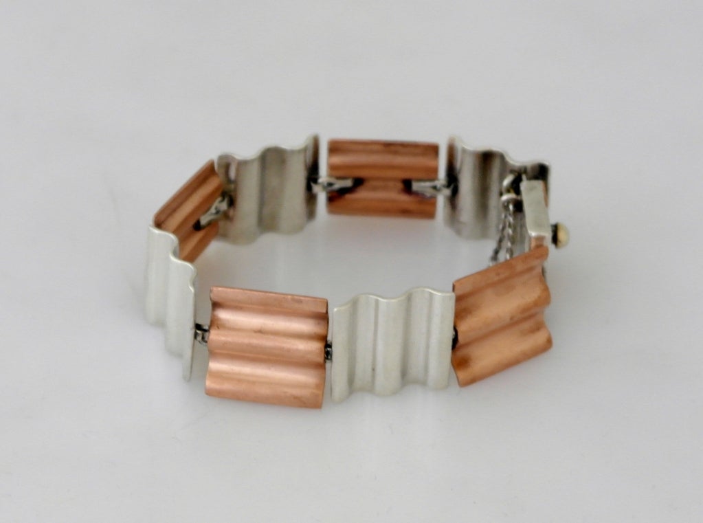 Being offered is a rare circa 1957 sterling silver & copper bracelet by Antonio Pineda of Taxco, Mexico., of modernist design, each 'wafer' measuring 3/4 inches by 13/16 inches, the wafer links resembling the contoured sections of an industrial