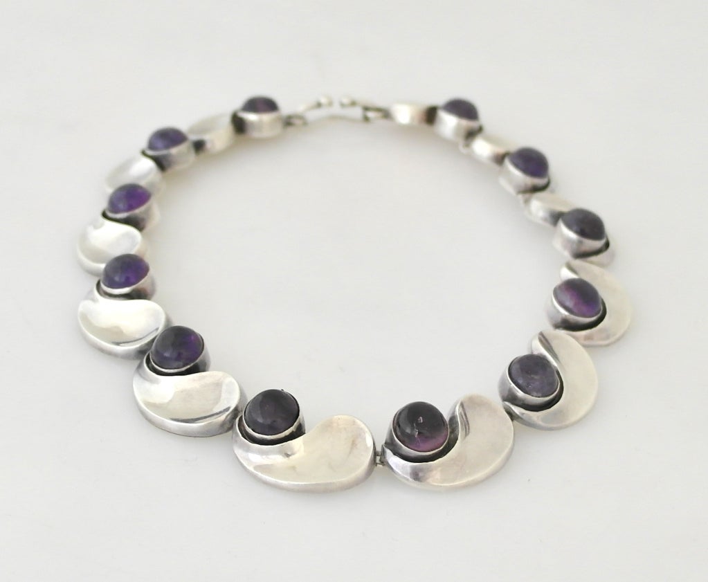 Being offered is a circa 1968 .970 silver necklace by Antonio Pineda of Taxco, Mexico; comprising twelve links in the sought after 'comma' design with amethyst stones. Dimensions: wearable 15 1/2