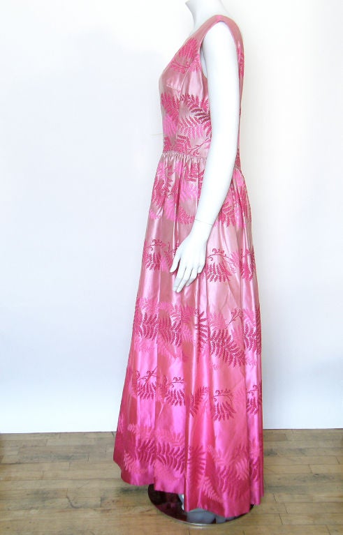 This wonderful silk gown has a simple, classic shape that is transformed by the high impact fabric. The fabric is very unusual with an intense fade from a saturated, vivid fuschia at the hem to a soft, pale pink at the bodice and a pattern of fern
