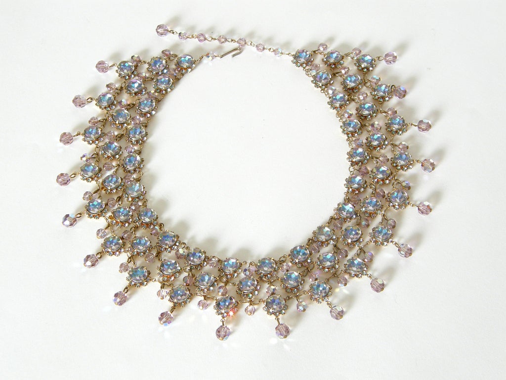 Dramatic bib necklace featuring festoons of pink and blue aurora borealis rhinestones and faceted beads. The rhinestones have flat tops with all of the faceting on their undersides.

Please contact us if you have any questions.