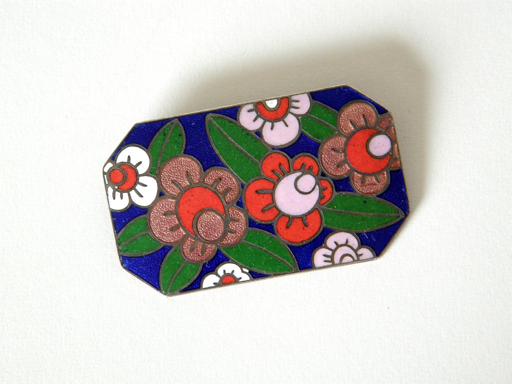 Enameled brooch with stylized, art deco flowers. The design is rendered in opaque and translucent enamel. The pin has a sliding barrel type clasp.

Unmarked, but possibly Eastern European.

Please contact us if you have any questions.