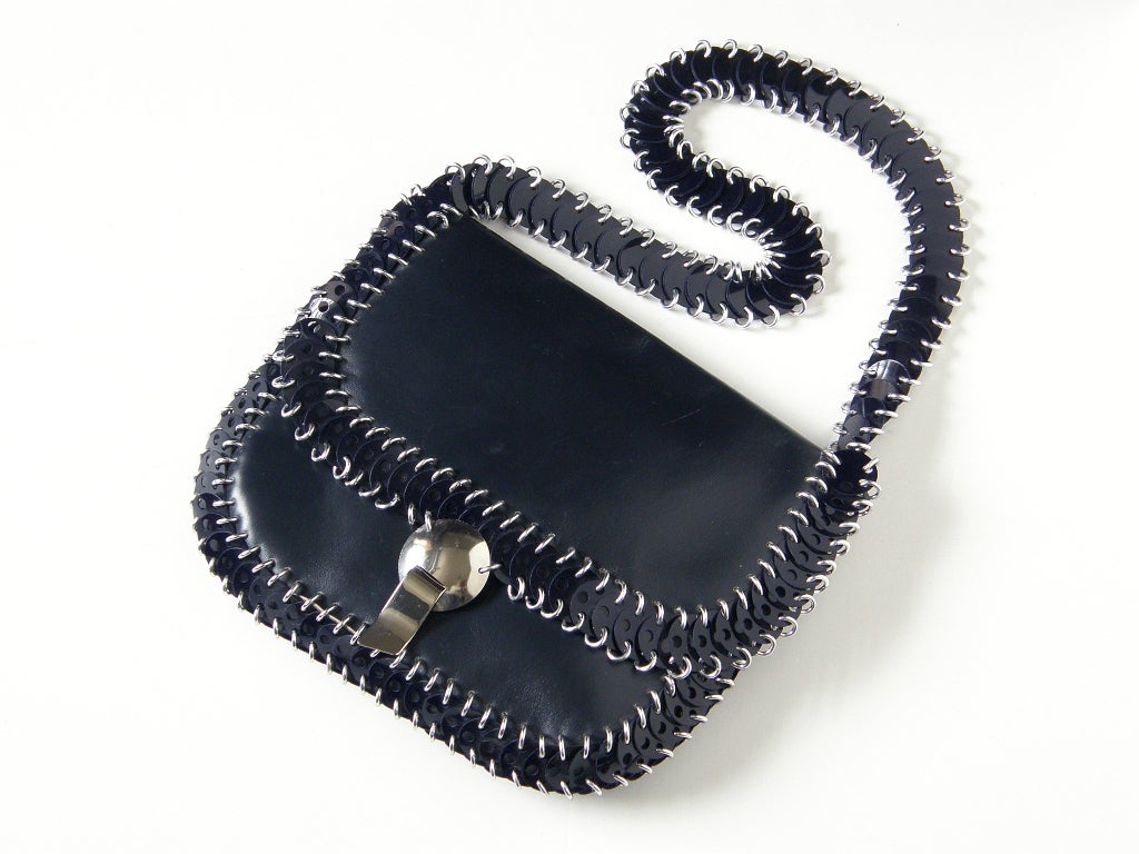 Paco Rabanne shoulder bag in navy blue leather and plastic disks. The disks are attached with aluminum links, and the bag has a dome shaped chrome clasp with a tab and slot closure. The bag measures 19.5" high to the top of the strap.