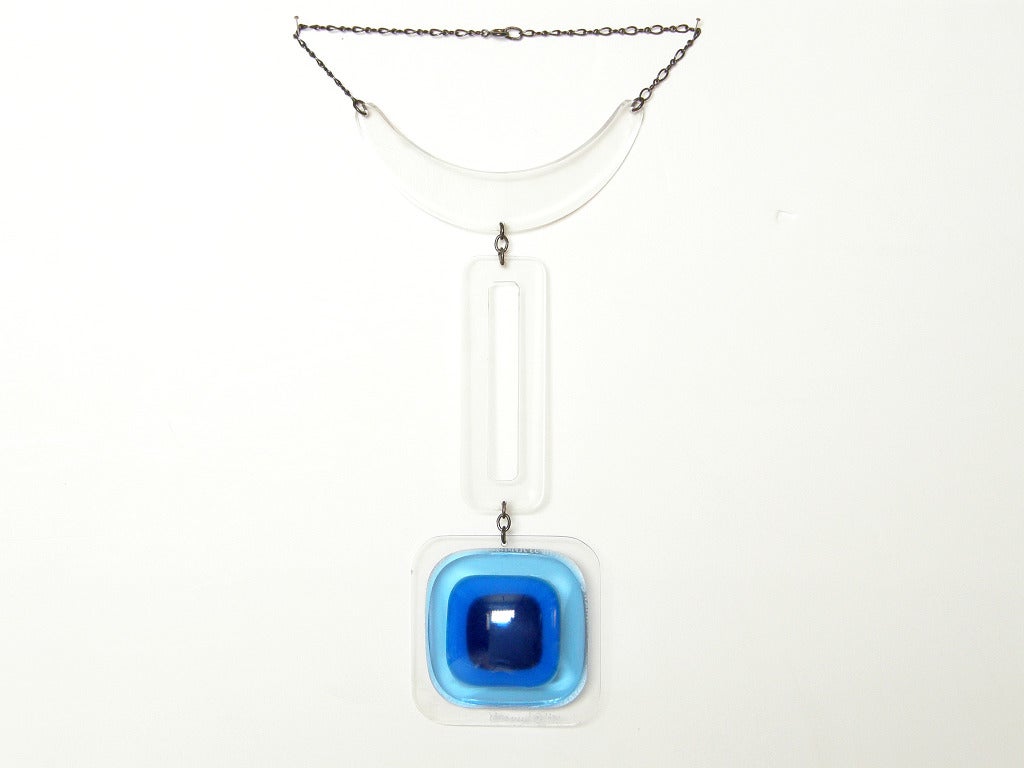 This bold, modern necklace by Aaronel DeRoy Gruber has a space age style. The subtlety of the clear acrylic shapes offsets the pop of the three-dimensional bubble pendant in shades of blue. The chain is sterling. The piece is signed and dated 1971.